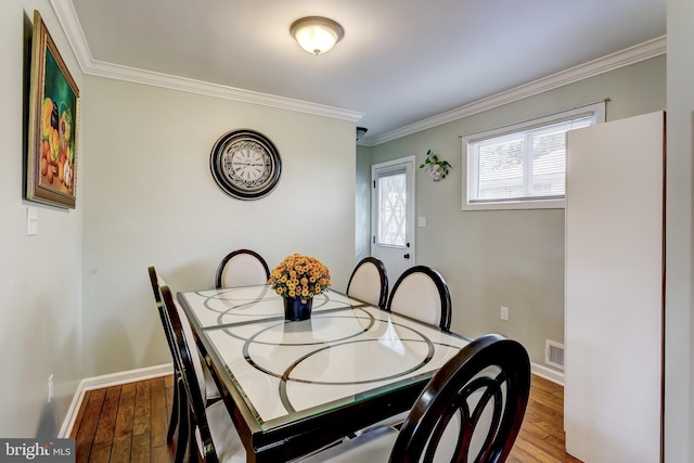 dining space with crown molding and hardwood / wood-style flooring