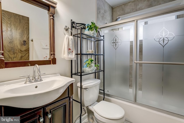 full bathroom featuring enclosed tub / shower combo, vanity, and toilet