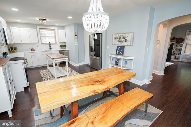 dining area with dark hardwood / wood-style floors, sink, and a chandelier