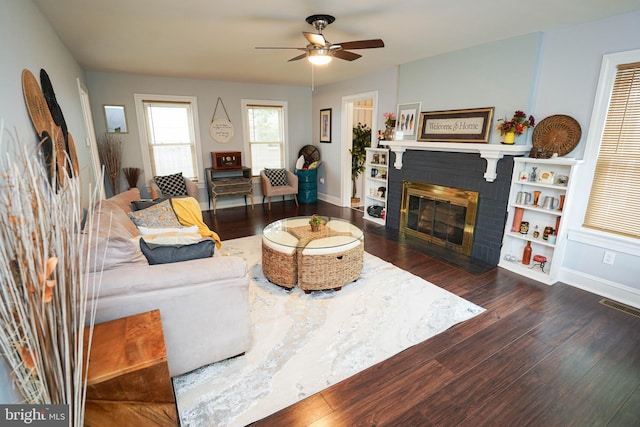 living room featuring a fireplace, dark hardwood / wood-style flooring, and ceiling fan