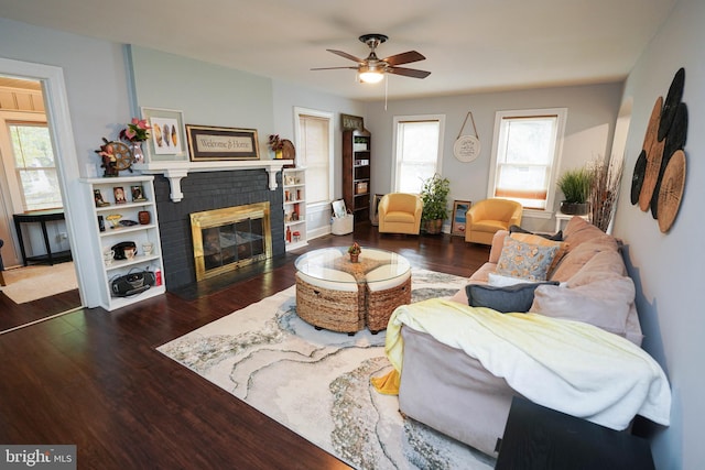 living room featuring ceiling fan, a fireplace, and dark hardwood / wood-style floors