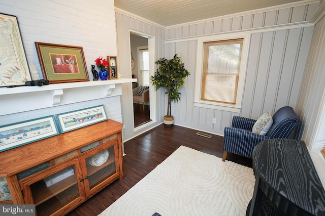 living area featuring ornamental molding and dark hardwood / wood-style floors