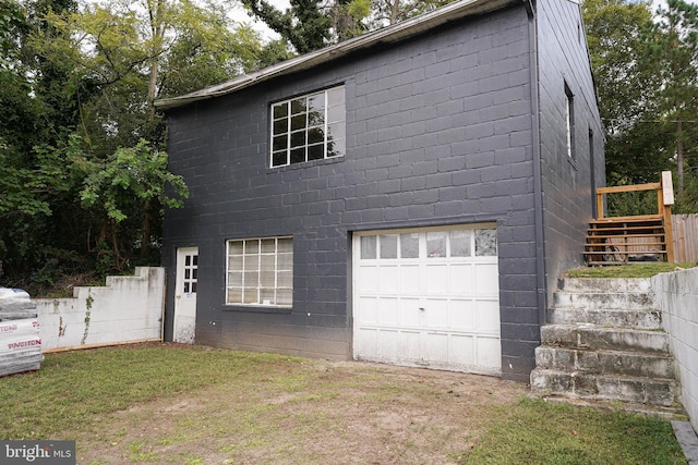 exterior space featuring a garage and a lawn