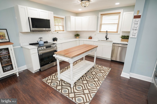 kitchen with stainless steel appliances, white cabinets, dark hardwood / wood-style floors, and sink