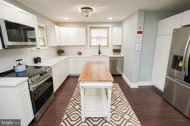 kitchen with appliances with stainless steel finishes, sink, and white cabinetry