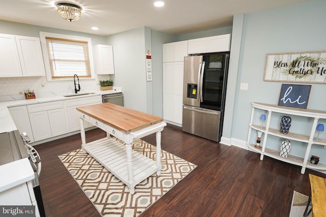 kitchen with stainless steel appliances, white cabinetry, dark hardwood / wood-style floors, and sink