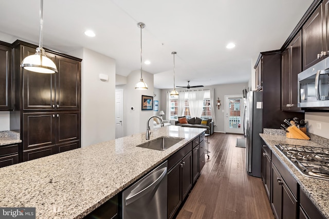 kitchen featuring stainless steel appliances, dark brown cabinets, decorative light fixtures, dark hardwood / wood-style floors, and sink