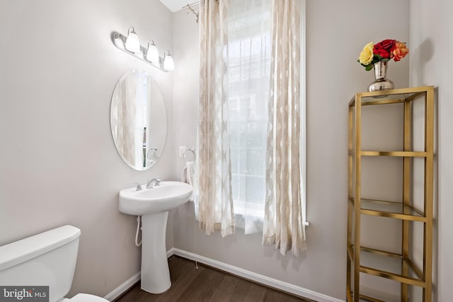 bathroom with hardwood / wood-style flooring, toilet, and a wealth of natural light