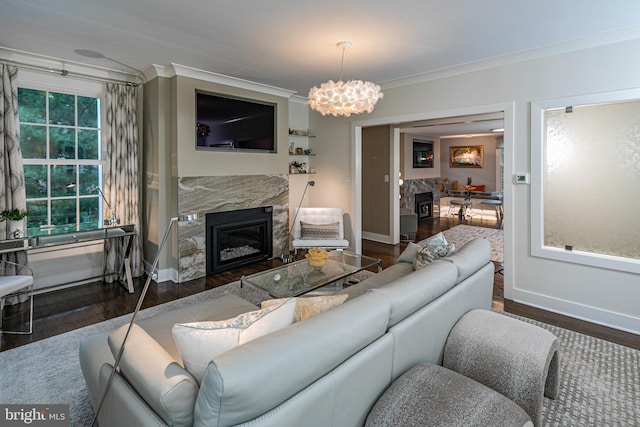 living room with an inviting chandelier, hardwood / wood-style floors, a fireplace, and crown molding