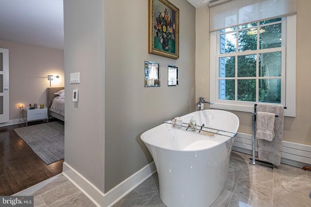 bathroom featuring hardwood / wood-style floors, a tub, and a wealth of natural light