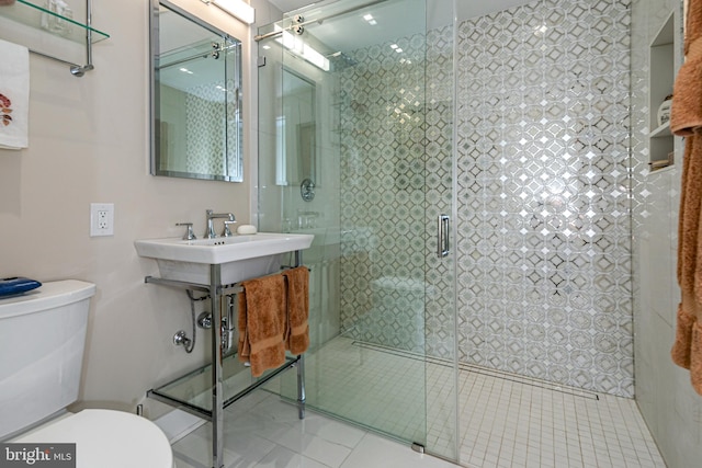 bathroom with a shower with door and toilet