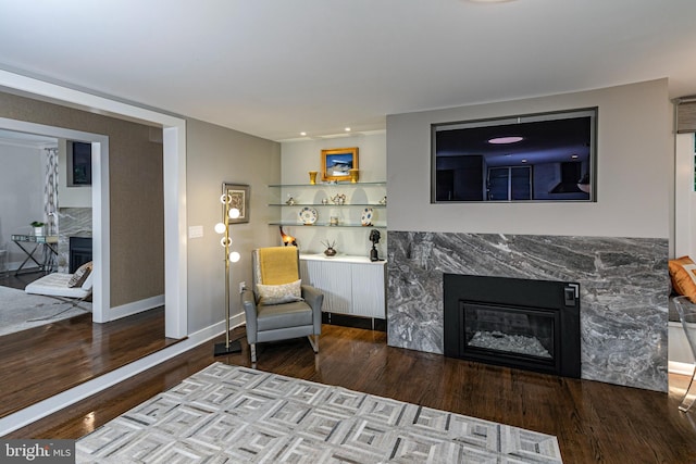 sitting room with a premium fireplace and hardwood / wood-style flooring