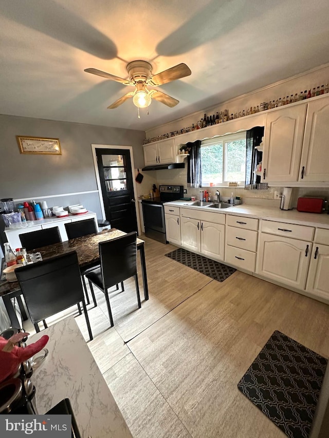 kitchen featuring light hardwood / wood-style floors, sink, white cabinets, ceiling fan, and black range with electric cooktop