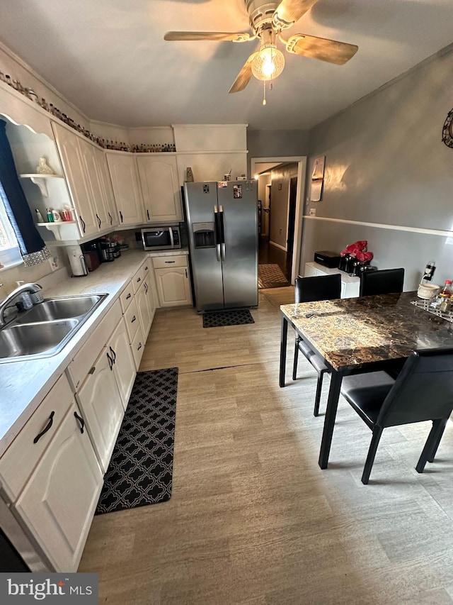 kitchen featuring stainless steel appliances, white cabinets, ceiling fan, and sink