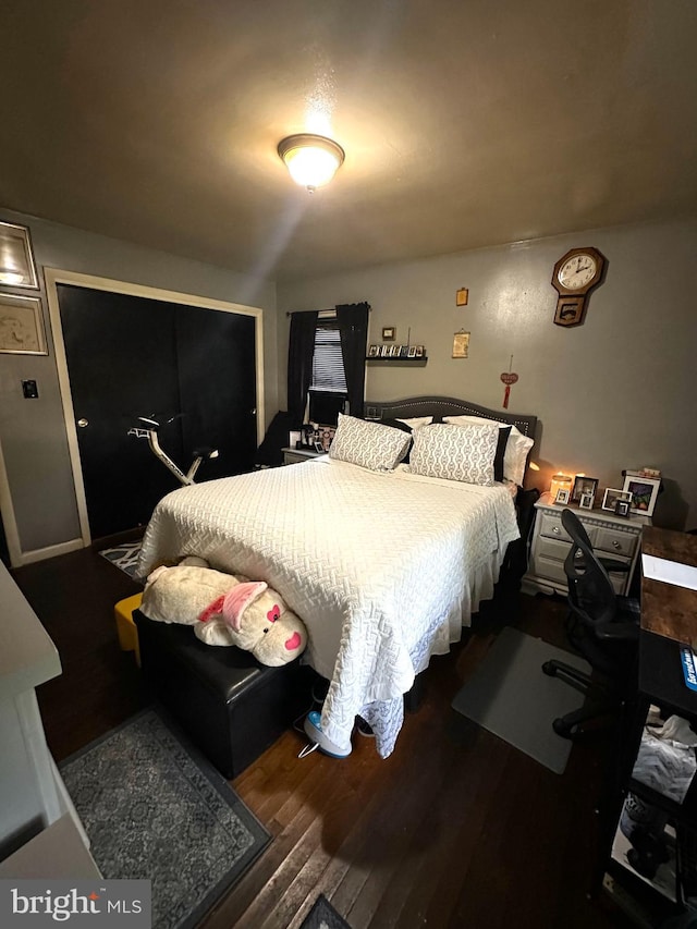 bedroom with dark hardwood / wood-style floors