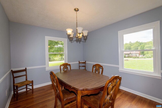 dining room featuring an inviting chandelier, dark hardwood / wood-style flooring, and a textured ceiling