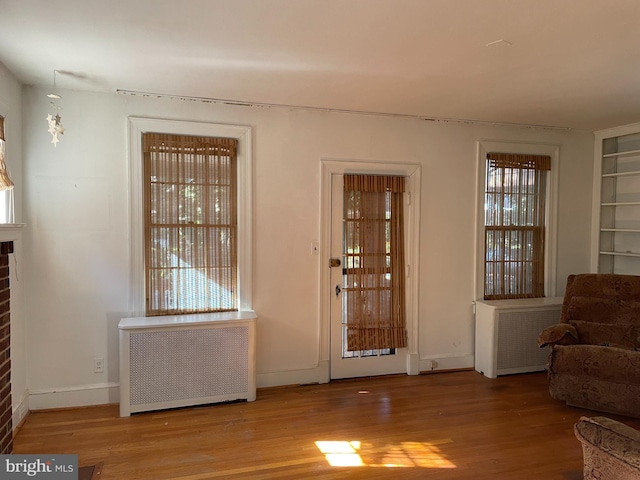 4527 S Dakota Ave NE, Washington, DC 20017 - entryway featuring baseboards, radiator heating unit, wood finished floors, and a fireplace