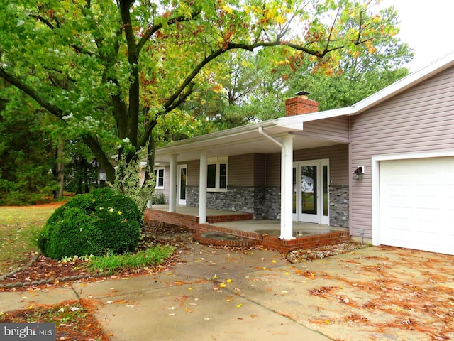 view of side of home featuring a porch and a garage