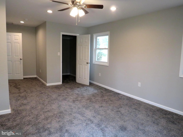 unfurnished bedroom featuring ceiling fan and dark carpet