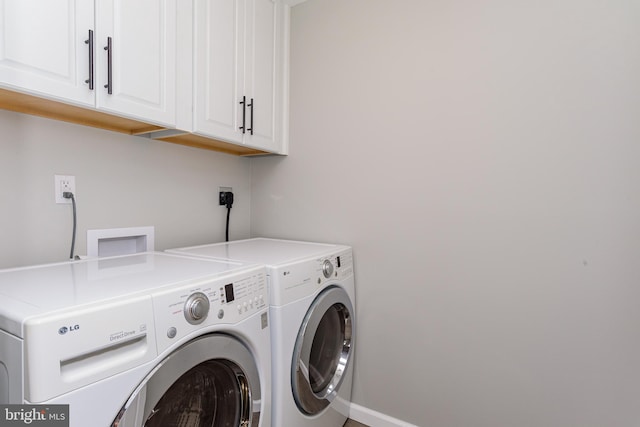 laundry room with cabinets and washing machine and clothes dryer