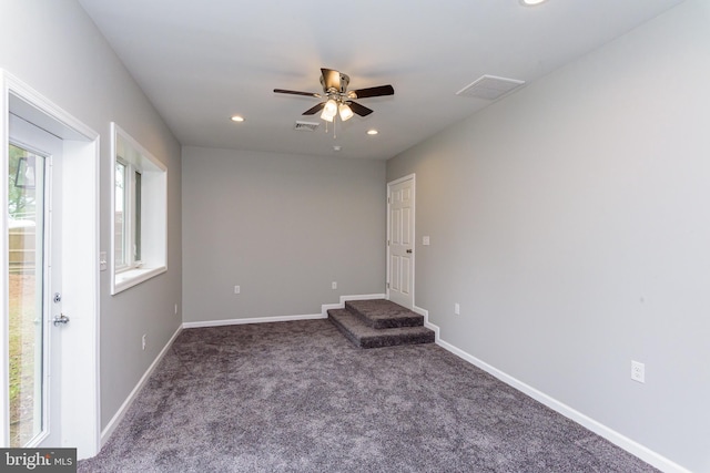 carpeted spare room featuring ceiling fan