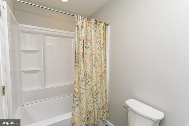 bathroom with toilet and shower / bath combo with shower curtain