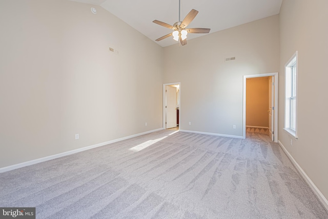 carpeted empty room featuring ceiling fan and high vaulted ceiling