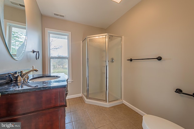 bathroom with tile patterned floors, toilet, a shower with door, vaulted ceiling, and vanity