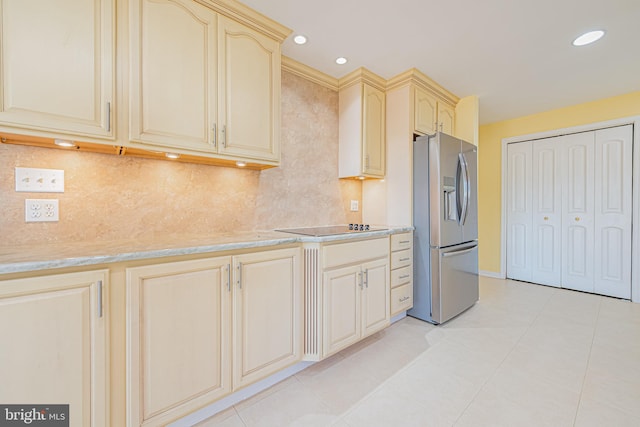 kitchen with light stone counters, stainless steel fridge with ice dispenser, light tile patterned floors, and cream cabinetry