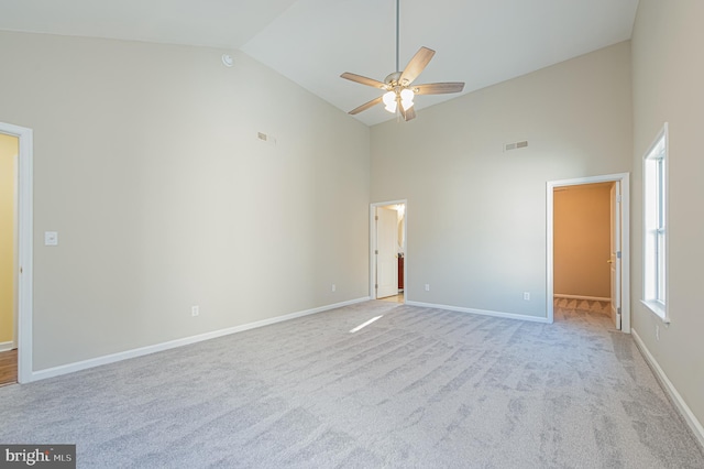 unfurnished bedroom with ceiling fan, high vaulted ceiling, a walk in closet, and light colored carpet