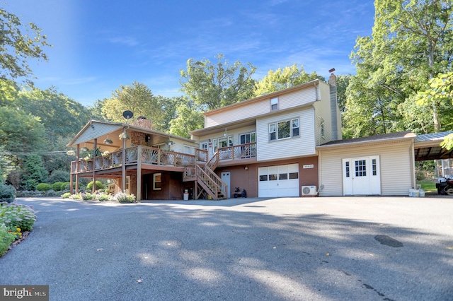 650 Bucks Church Rd, Newport, PA 17074 - rear view of house featuring stairs, a garage, a chimney, a wooden deck, and asphalt driveway