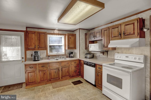 650 Bucks Church Rd, Newport, PA 17074 - kitchen with white appliances, a sink, under cabinet range hood, brown cabinetry, and ornamental molding