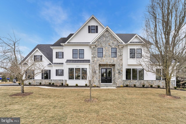 view of front of house featuring stone siding, a standing seam roof, a front yard, and board and batten siding