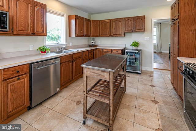 kitchen featuring wine cooler, stainless steel appliances, sink, and light tile patterned flooring