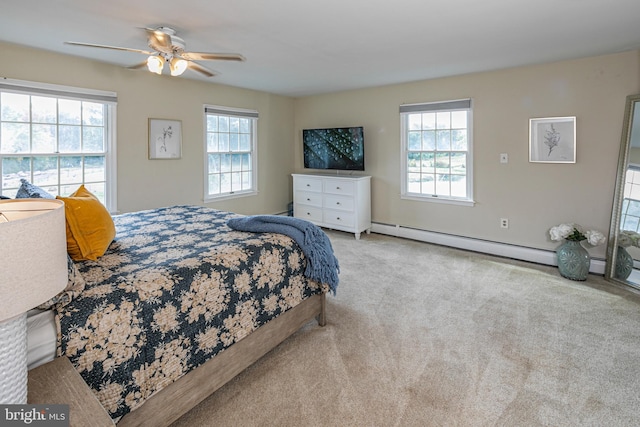 bedroom featuring multiple windows, ceiling fan, a baseboard radiator, and light colored carpet