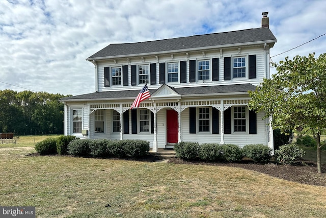 view of front facade with a front yard and covered porch