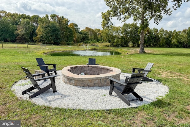 exterior space with a water view, a fire pit, and a yard