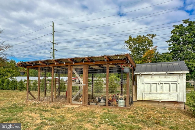 view of property's community featuring a yard and an outbuilding