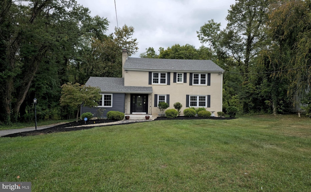 colonial-style house with a front lawn