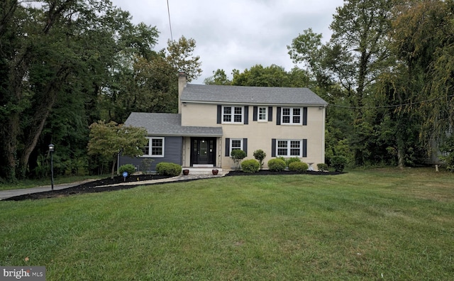 colonial-style house with a front lawn