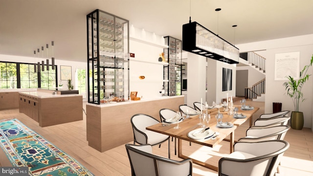 dining room with light hardwood / wood-style flooring and a high ceiling