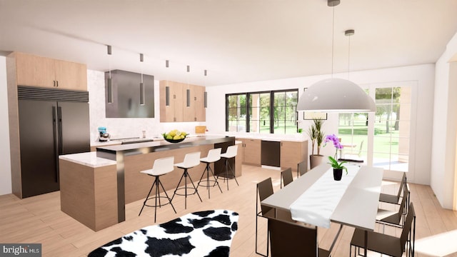 kitchen featuring hanging light fixtures, light hardwood / wood-style floors, a kitchen island, light brown cabinetry, and built in fridge