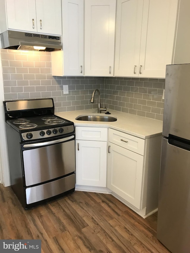 kitchen with sink, stainless steel appliances, tasteful backsplash, white cabinets, and dark hardwood / wood-style flooring