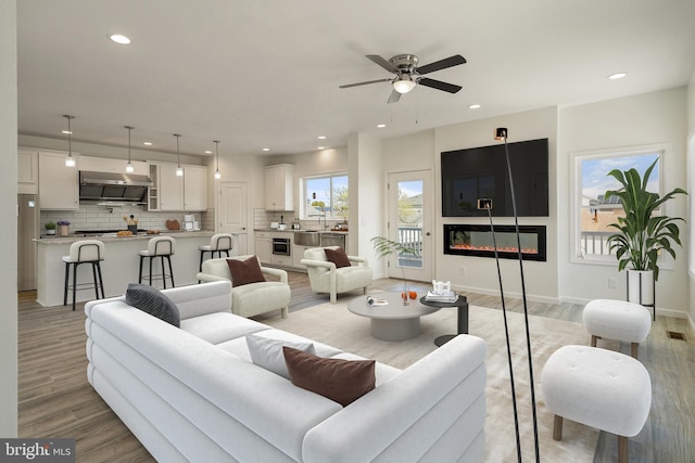 living room with ceiling fan and light hardwood / wood-style floors