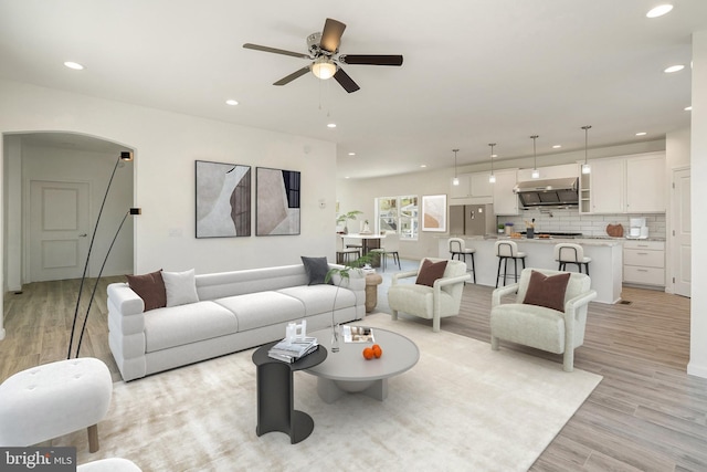 living room with ceiling fan and light wood-type flooring