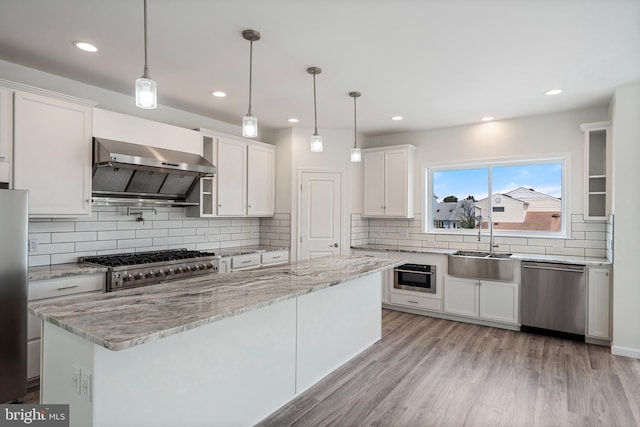 kitchen with light hardwood / wood-style floors, sink, white cabinetry, wall chimney exhaust hood, and appliances with stainless steel finishes