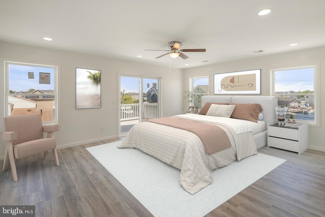 bedroom with ceiling fan, multiple windows, access to exterior, and wood-type flooring