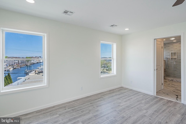 spare room featuring ceiling fan and light hardwood / wood-style floors