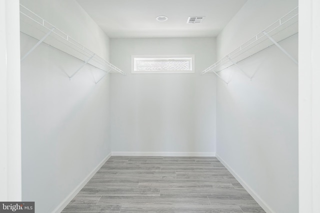 walk in closet with light wood-type flooring