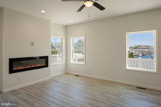 unfurnished living room featuring light hardwood / wood-style floors and ceiling fan